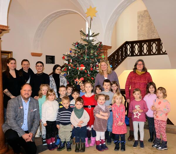 Landrat Gaarz und die Kinder und ihre Erzieherinnen vor dem geschmückten Weihnachtsbaum