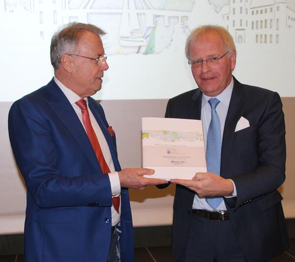 Verlagschef Rainer Wendorff übergibt Landrat Reinhard Sager das erste Buch