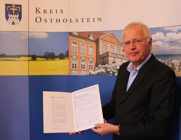 Landrat Sager mit Urkunde