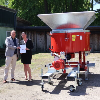 Landrat Gaarz und B&uuml;rgermeisterin Sch&auml;fer neben der Sandsackf&uuml;llanlage
