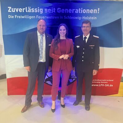 Landrat Gaarz (l.) und Innenstaatssekretärin Magdalena Finke (m.) gratulieren Kreiswehrführer Michael Hasselmann (r.)