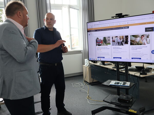 Landrat Timo Gaarz (l.) und Digitalisierungsmanager Heiko Nowak (r.) sprechen über die Möglichkeiten der neuen Engagementbörse