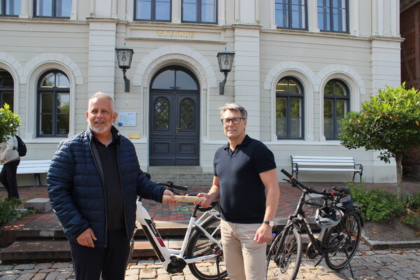 Heiligenhafens Bürgermeister Kuno Brandt übergibt des Staffelstab an Oldenburgs Bürgermeister Jörg Saba