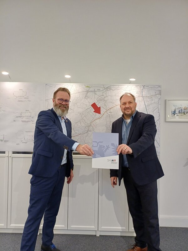 Bild vergrößern: Minister Claus Ruhe Madsen bergibt den Frderbescheid an Landrat Timo Gaarz