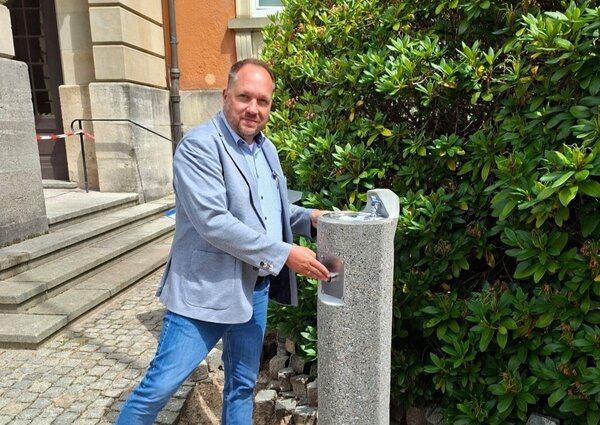 Bild vergr&ouml;&szlig;ern: Landrat Timo Gaarz am neuen �ffentlichen Wasserspender vor dem Kreishaus. Der Wasserspender steht allen Besucherinnen und Besuchern sowie Passantinnen und Passanten kostenfrei zur Verf�gung.
