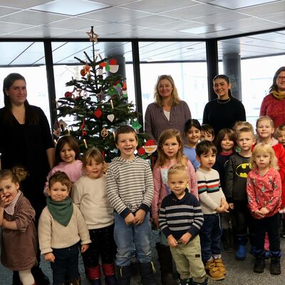 Bild vergrößern: Die Kinder mit ihren Erzieherinnen vor dem geschmckten Baum